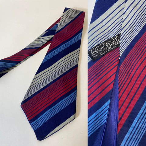 1940s Tootal tie, special quality label in blue red and grey multi stripe pattern. Open backs and short blade at 120cm long 10cm wide. No damage.