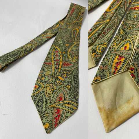 1950s British tie in mint green with mustard yellow and red paisley pattern. Lined with open backs and fairly short at 134cm long and 8cm wide.