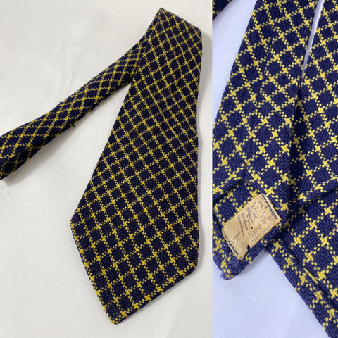 1940s wool tie, British made, thick hand woven, Altex label. Dark navy blue with yellow box check. No lining and open backs with short blade at 123cm long and 10.5cm wide. Two little holes have been repaired in matching wool.