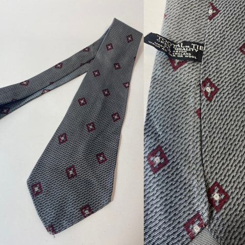 1940s Tootal tie in grey quality label in grey pattern with red motif pattern. No lining and open backs with short blade at 122cm long and 8 cm wide. No damage.