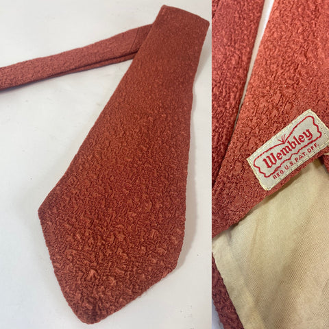 1950s US tie Wembley label in crimp pattern fabric in terracotta brown. Open backs and fairly short blade at 130cm and 9cm  wide. No damage.