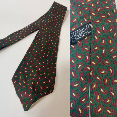 1940s Tootal tie black quality label in bottle green with red and yellow paisley motif pattern. Open backs and short blade at 125cm long and 8cm wide. No damage.