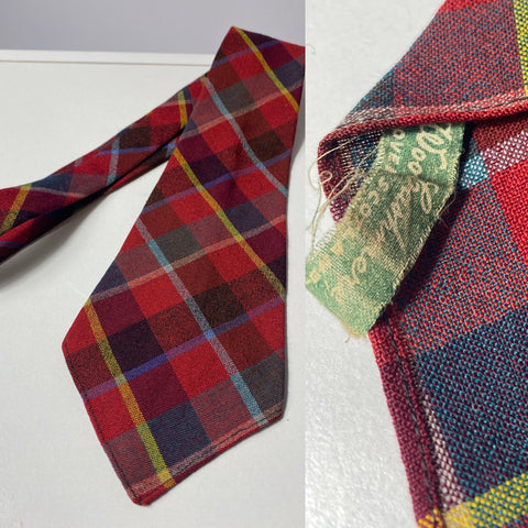 1940s tie made in Scotland wool & cashmere in red black blue and yellow plaid. No lining, open backs and short blade at 120cm long 10cm wide. No damage.