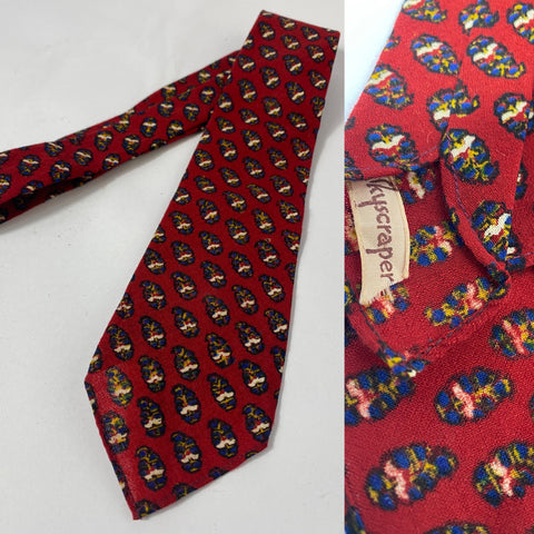 1940s tie red with blue yellow and cream repeat motif pattern. Open backs? No lining and short blade at 113cm long and 8cm wide. No damage.