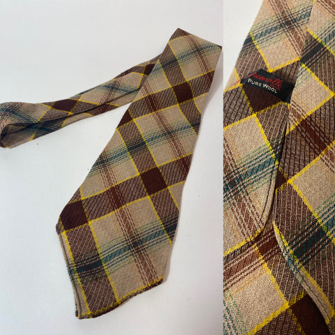 1940s Grenville tie in fawn brown green and yellow plaid pattern. No lining and open backs with short blade at 120cm long and 9cm wide. No damage.