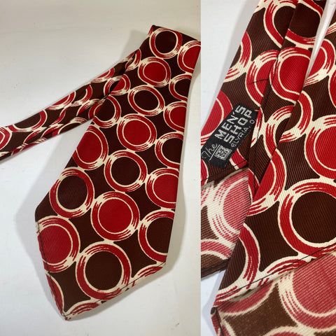 1940s US swing tie, The men’s shop Elyria label. Red brown and white circular pattern. No lining and open backs with short blade at 120cm - 10cm wide. Clean, mint condition.