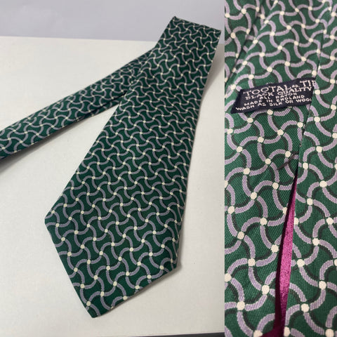 Early 50s Tootal tie in black quality label in bottle green with white and grey wave pattern. Open backs and short blade at 124cm long and 10cm wide. No damage.