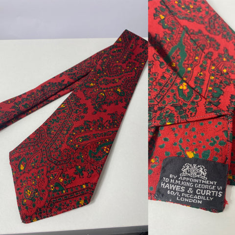 1940s tie Hawes & Curtis London by appointment to HM King George VI. Red with green and yellow pattern. No lining and open backs with short blade at 120cm long 9cm wide. No damage.