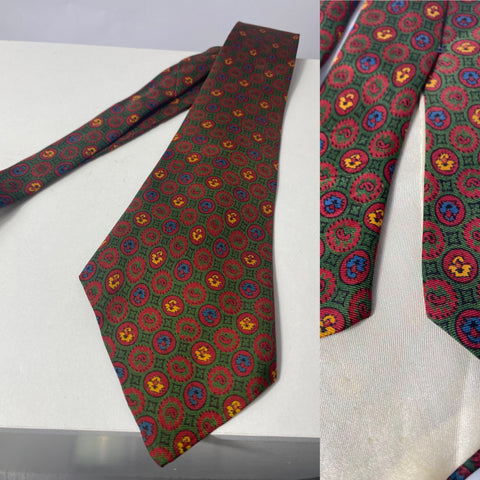1950s pure silk tie British made with red yellow and blue motif pattern. White silk lined with open backs and blade at 138cm long 9cm wide. No damage.