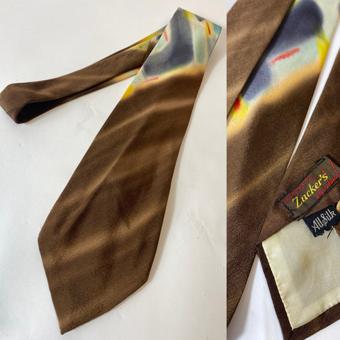 Hand painted silk swing era tie, Zuckers, Cleveland label. Beautiful brush work by hand in abstract pattern with brown, sky blue, yellow and red. Lined with open backs and short blade at 127cm long 10cm wide. No damage.