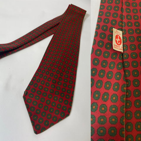 1950s British JC silk tie in red with green floral motif pattern. Open backs and fairly short blade at 130cm long and 8cm wide. No damage.