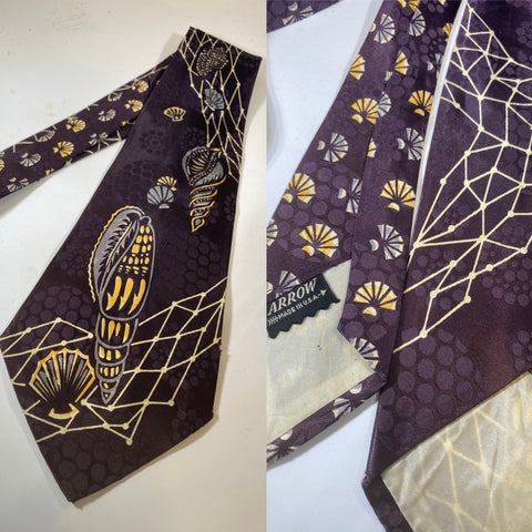 1940s swing tie in dark purple with shell and abstract grid design in white and yellow. Arrow label, lined with open backs and short blade at 129cm and 10cm wide. No damage.