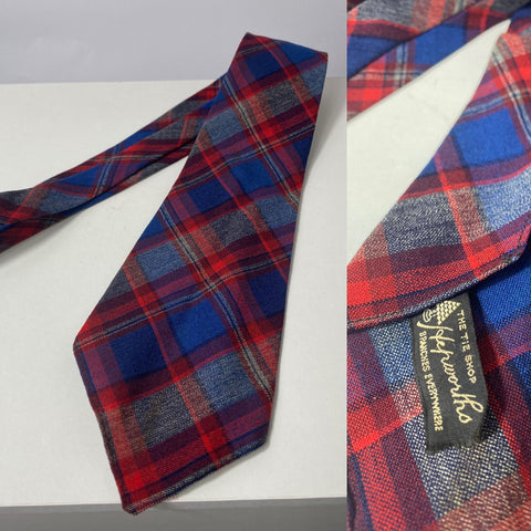 1940s tie by Hepworths in blue and red plaid pattern. No lining with open backs and short blade at 127cm long and 10cm wide. No damage.
